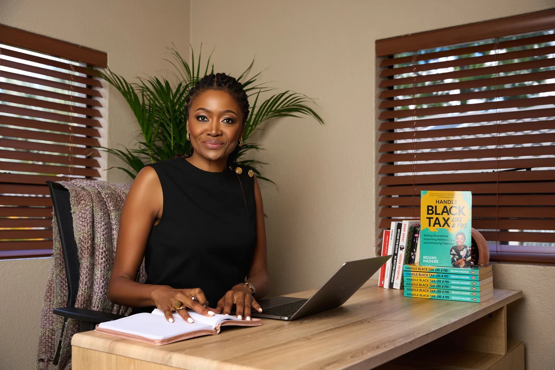 Ndumi Hadebe at a desk with her book